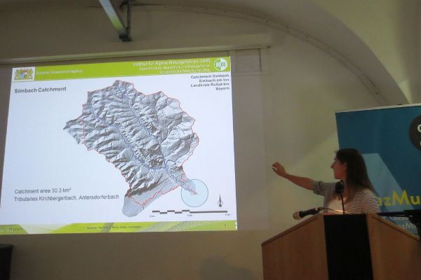 Powerpoint Folie an der Wand und Vortrag zu Ereignissen in Bayern