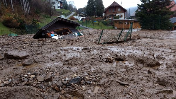 Schlamm, Geschiebe und Geröll auf den Straßen und Gräten sowie eine zerstörte Gartenhütte nach einem Murereingnis am Hoferbergbach