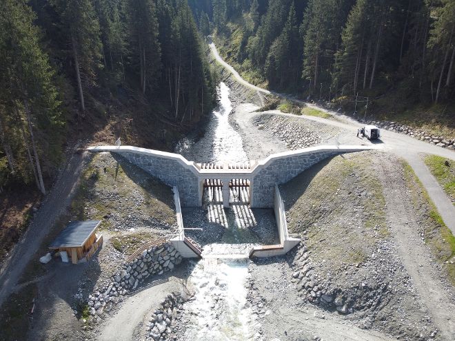 Aus der Vogelperspektive wird die gesamte Feststoffmonitoring-Messstelle am Habach gezeigt mit der Wildbachsperre sowie dem Retentionsbecken und den Messeinrichtungen. 